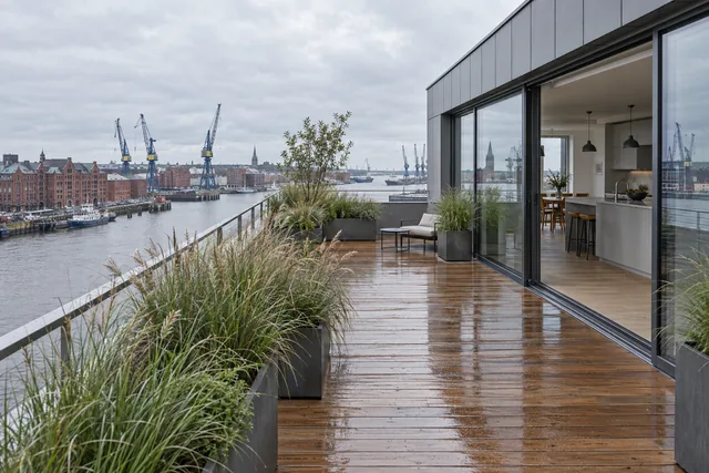 Dachterrasse mit Holzdeck und Blick auf Hafenkräne und Speicher